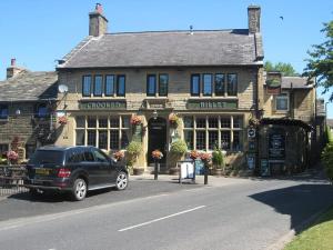 a black car parked in front of a building at The Guest House Worsthorne in Burnley