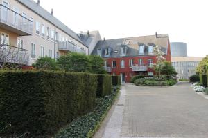 un trottoir à côté de certains bâtiments avec buissons dans l'établissement Studio des jardins suspendus, à Liège