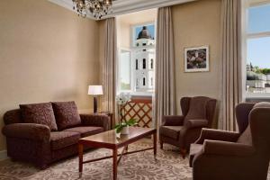 - un salon avec des canapés, des chaises et une table dans l'établissement Grand Hotel Vilnius, Curio Collection by Hilton, à Vilnius