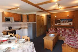 a kitchen and a living room with a table and chairs at Vanoise Appartements VTI in Val Thorens