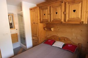 um quarto com uma cama e armários de madeira em Vanoise Appartements VTI em Val Thorens