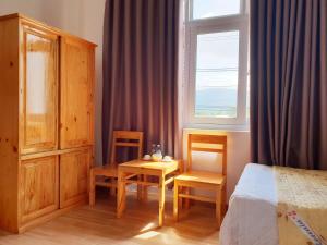 a bedroom with a bed and a table and a window at Phú tài center hotel in Phú Thạnh