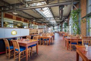 an empty restaurant with wooden tables and chairs at Hotel Dömitzer Hafen in Dömitz