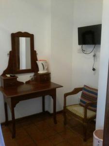 a bathroom with a table and a mirror and a chair at Secret Palace Guest house in Galle