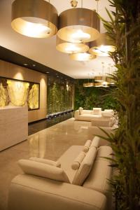a lobby with couches and plants and lights at Royal G Hotel and Spa in Durrës