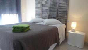 ein Schlafzimmer mit einem Bett mit einem grünen Handtuch darauf in der Unterkunft Casa Fontanella in Pal