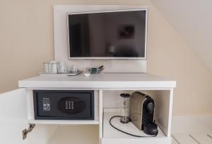 a microwave in a white cabinet with a tv on top at Remise Thurn in Heroldsbach +1 photo