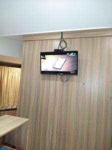 a flat screen tv on top of a wooden wall at golden dormitory in Mumbai