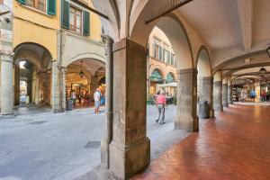 an arcade in a building with people walking on the street at Il Silenzioso in Pisa