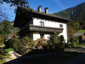biały dom z górą w tle w obiekcie Sportpension Schober w mieście Obertraun