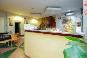 a restaurant with a bar with a sign on the counter at RedDoorz near Bethesda Manado in Manado