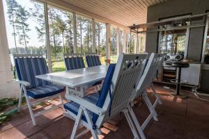 einen Tisch und Stühle auf einer abgeschirmten Veranda in der Unterkunft Villa Harald - Beachfront in Hitis