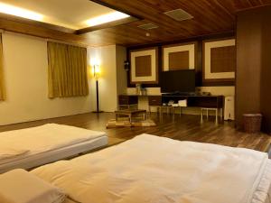 a bedroom with two beds and a flat screen tv at Fenchihu Hotel in Fenqihu