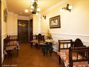 a living room with chairs and a table and a hallway at Hotel Boutique El Pescador in Cudillero