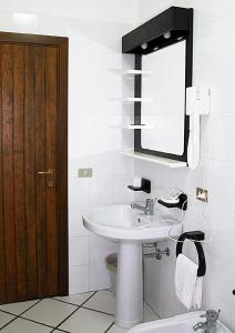 a bathroom with a sink and a mirror and a toilet at Residence Porto Mannu in Palau