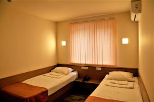 Habitación pequeña con 2 camas y ventana en Albert House Hotel and Tours, en Ereván