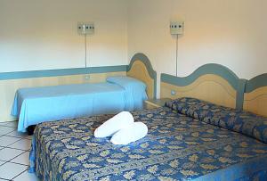 um quarto de hotel com duas camas com almofadas brancas em Residence Porto Mannu em Palau