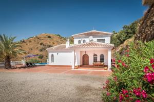 una pequeña casa blanca con una colina en el fondo en Villa El Ancla en Sayalonga