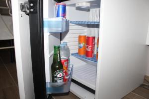 un frigorifero aperto pieno di bottiglie e lattine di soda di Bed & Breakfast San Marco a Taranto