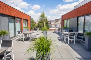 un patio con mesas y sillas en un edificio en Hotel Rastelli Tervuren, en Tervuren