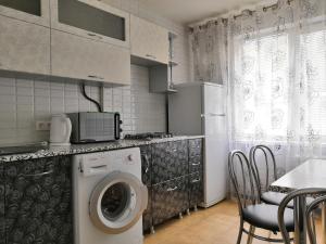 ヴォルシスキーにあるApartment on Mira 93のキッチン(洗濯機、テーブル、椅子付)