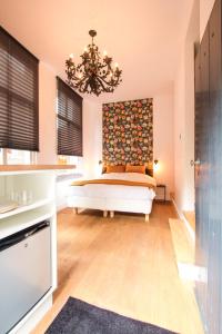 1 dormitorio con cama y lámpara de araña en Ververs slapen, en Den Bosch