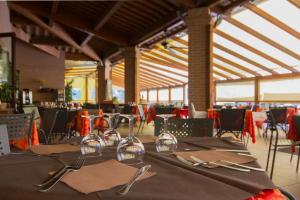 a dining room with a table with silverware on it at Villaggio Il Girasole in Follonica