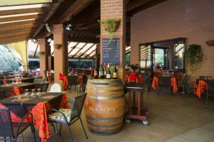 a restaurant with a bunch of tables with wine barrels at Villaggio Il Girasole in Follonica
