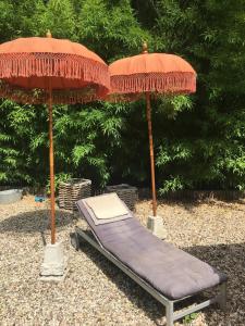 クレーフェルトにあるHouse Apricotの庭園内のベッド1台と傘2本