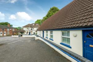 a building with blue doors and a parking lot at The Inn With The Well in Marlborough