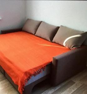 a couch with an orange blanket on top of it at Квартира in Kyiv