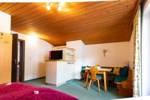 Zimmer mit einer Küche und einem Tisch sowie einem Zimmer mit einem Bett in der Unterkunft Petererhof in Gerlos