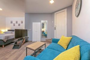 - un salon avec un canapé bleu et un lit dans l'établissement Mariva Downtown Studio, à Rovinj