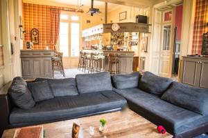 sala de estar con sofá azul y cocina en Golf Hotel, en Saint-Saëns