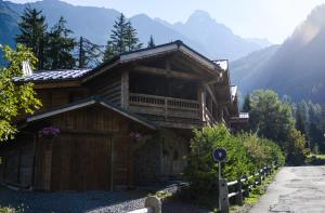 a wooden cabin with mountains in the background at Chalets Grands Montets in Chamonix