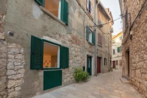 Une allée avec des volets verts dans un bâtiment dans l'établissement Mariva Downtown Studio, à Rovinj