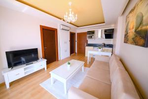 a living room with a couch and a tv at Sarajevo Suit Hotel in Kocaeli