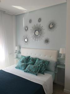 een slaapkamer met een bed met drie spiegels aan de muur bij "El Remanso" in La Manga del Mar Menor