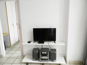 sala de estar con TV y mesa con ordenador. en Dumela Margate Flat No 14, en Margate