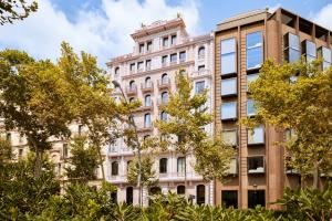 un antiguo edificio con árboles delante de él en Almanac Barcelona, en Barcelona