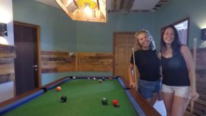 two women standing next to a pool table at Tiberias Hostel in Tiberias