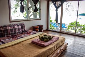 a bed in a room with windows and a bedvisor at Sangthain hills in Ko Samed