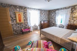 um quarto com uma cama, uma cadeira e janelas em Holiday home Neda em Sibenik