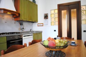 eine Küche mit einer Schale Obst auf einem Holztisch in der Unterkunft BNBOOK - BORROMEO 1 in Rho