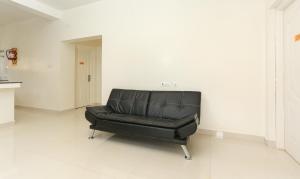 a black leather chair sitting in a white room at Treebo Trend Light House 900 Mtrs From Botanical Garden in Ooty