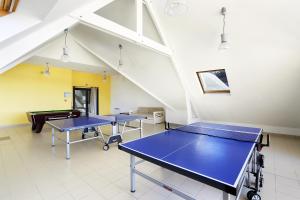 three ping pong tables in a room with ping pong balls at Résidence Néméa Iroise Armorique in Loc-Maria-Plouzané