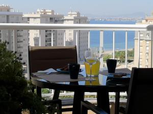 una mesa con una copa de vino en el balcón en "El Remanso", en La Manga del Mar Menor