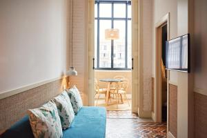 uma sala de estar com um sofá azul e uma mesa em Hotel Casa Bonay em Barcelona