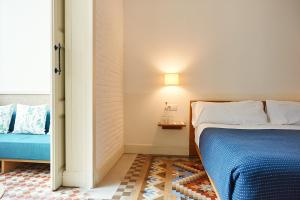 a bedroom with a bed and a lamp next to a window at Hotel Casa Bonay & Spa in Barcelona