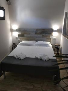 a bedroom with a large bed with white sheets and pillows at Dimora "I Santi Patroni" in Lecce